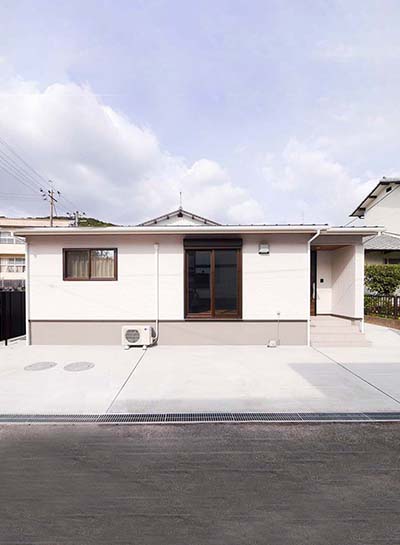 玄関ドアの木目が引き立つ、シンプルな中に温かみのある家