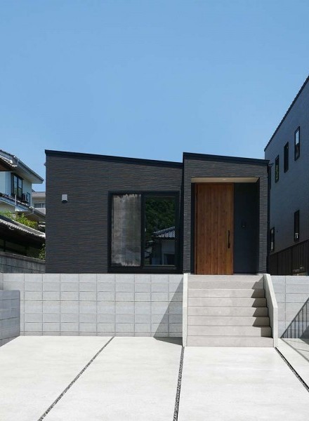 木目の玄関ドアがアクセントに映える、シックでモダンな住まい